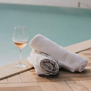 A glass of water and a towel on a wooden floor