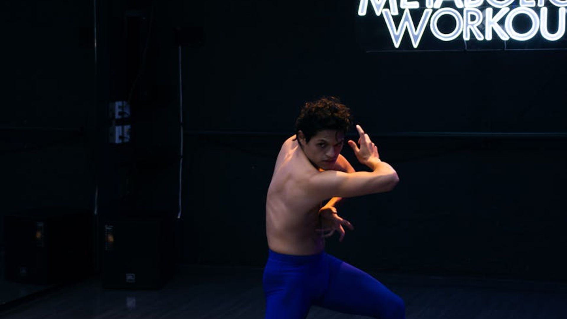 Athletic woman performing core exercises in a minimalist dark studio