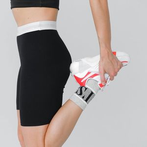 Close up of legs stretching on a black background